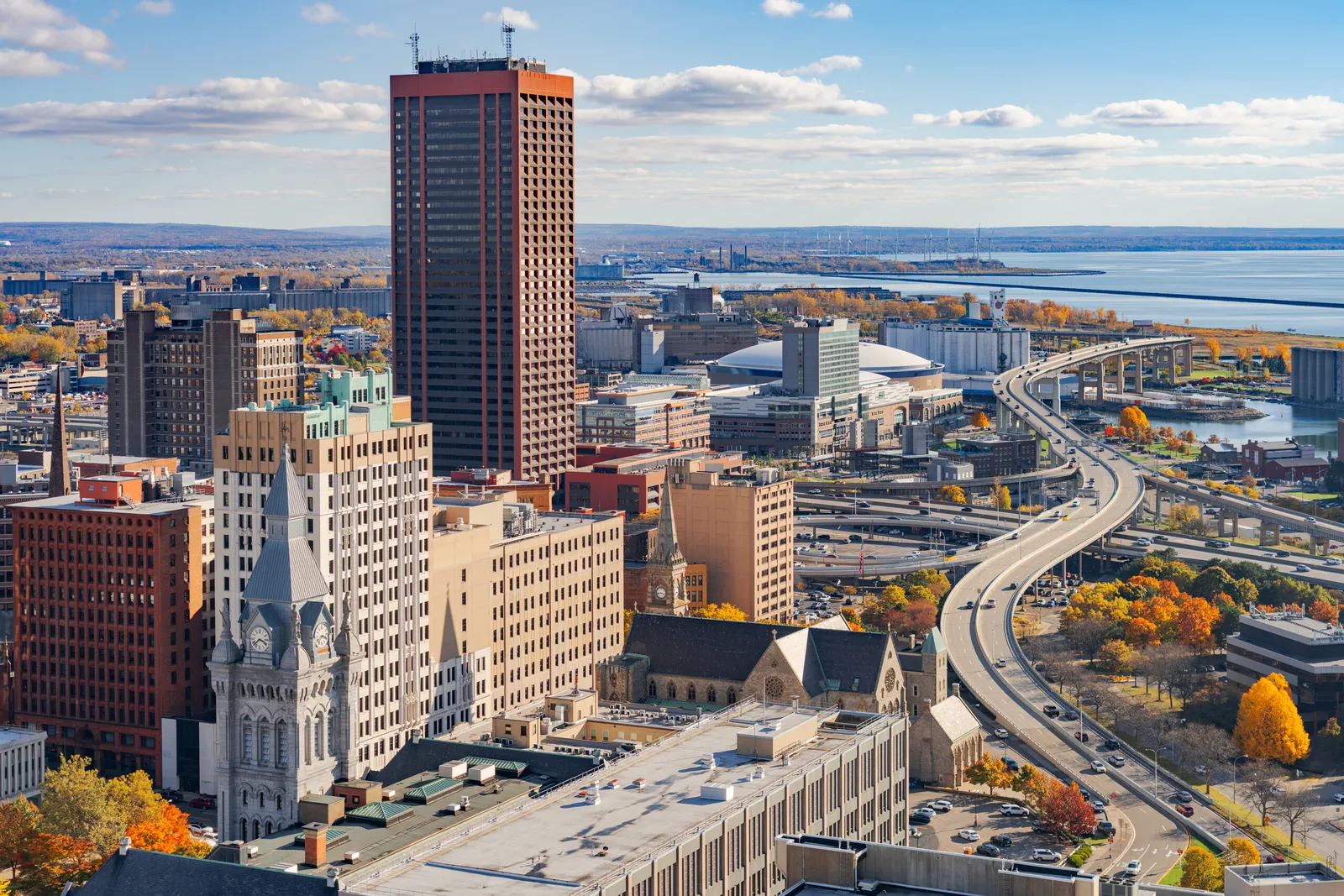 Downtown Buffalo in autumn, seen from above, with the Skyway curving toward Lake Erie